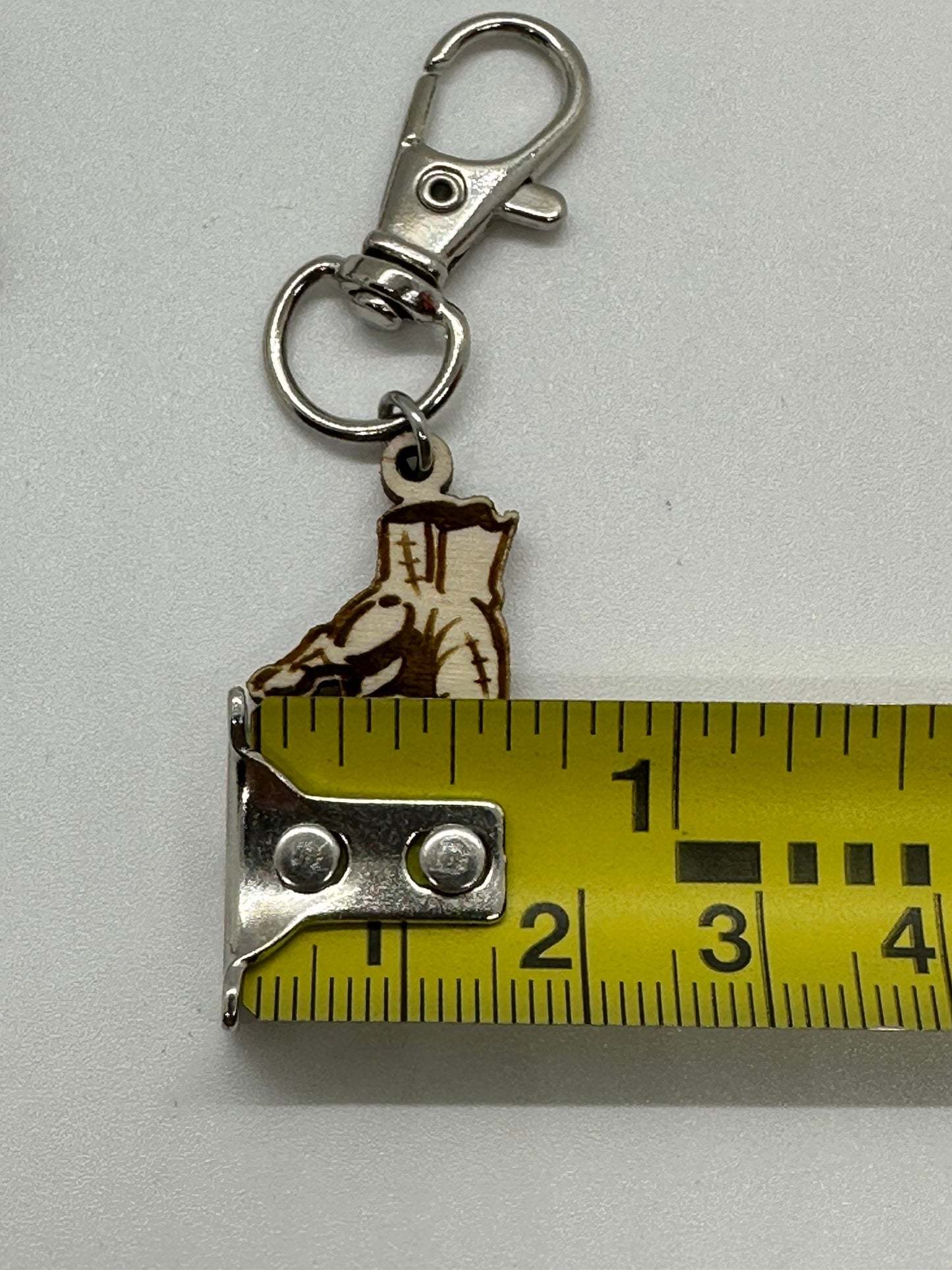 Keychain with hand design and measuring tape on a white background