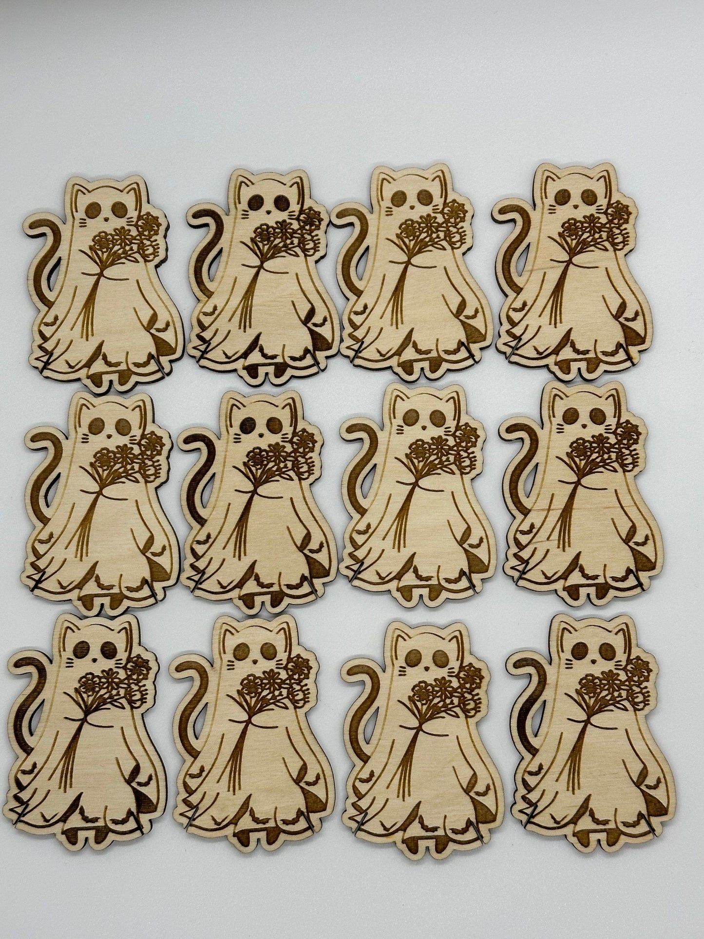 Set of wooden cat-shaped bobbins with floral bouquets on a white background