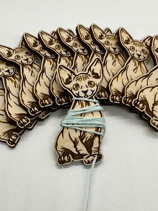 Wooden cat-shaped laser cutouts with string on a white background