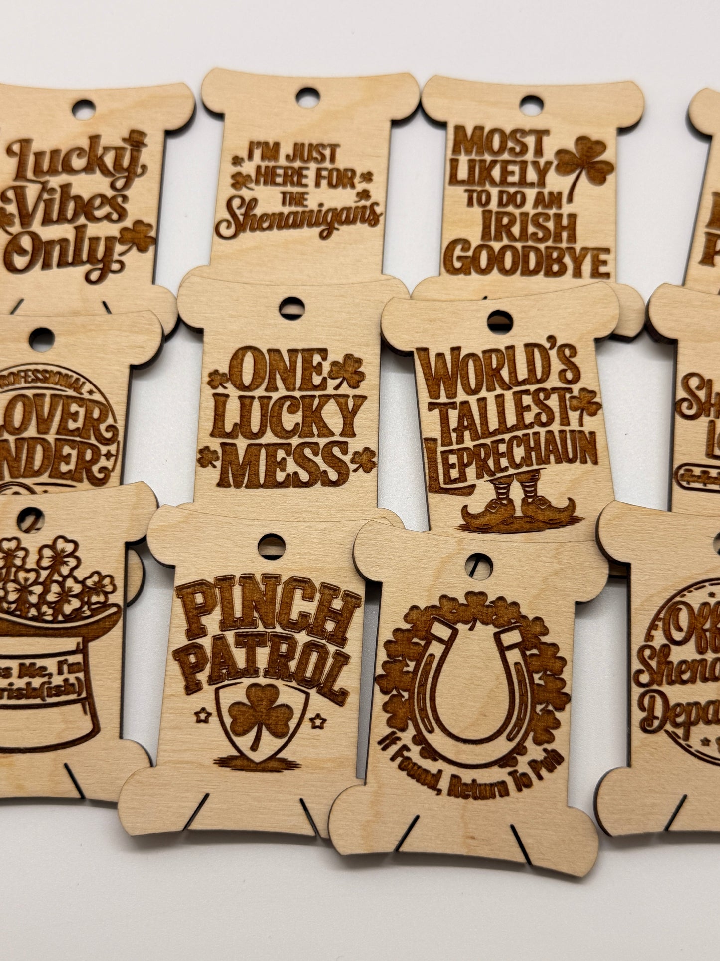 Wooden tags with laser-cut designs and text on a white background