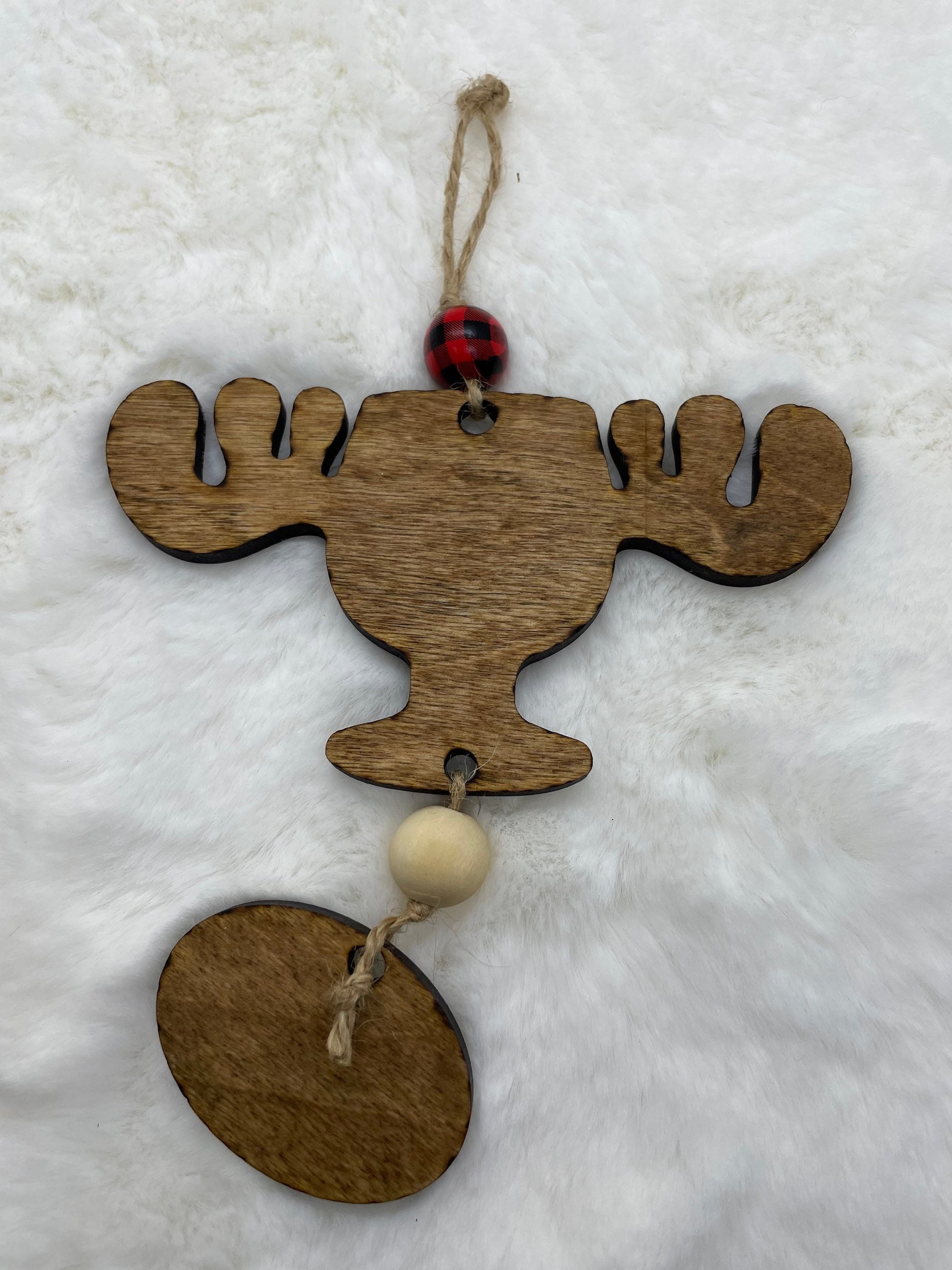 Wooden moose ornament with beads on a white background