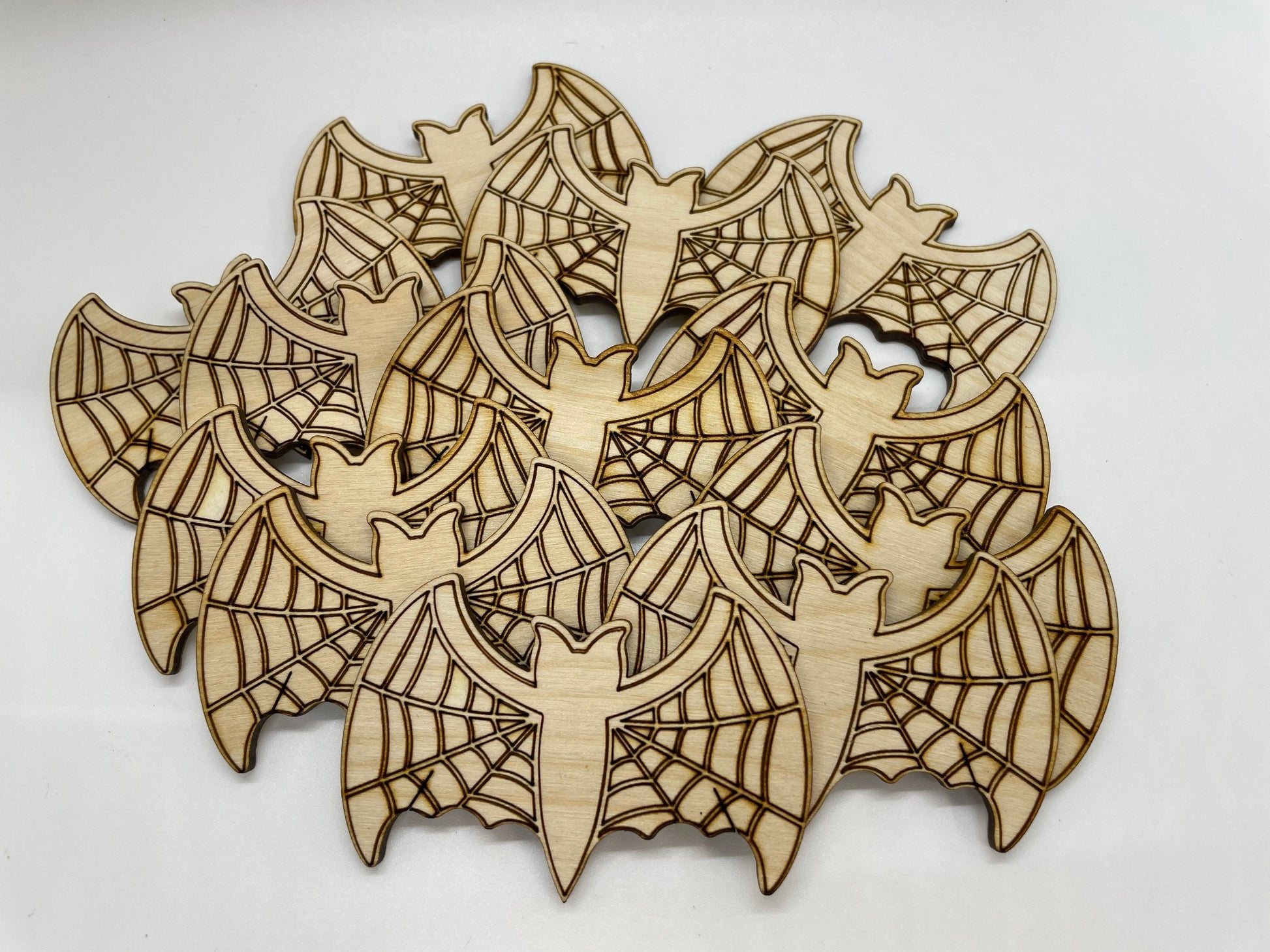 Wooden cutouts of bats and spider webs on a white background