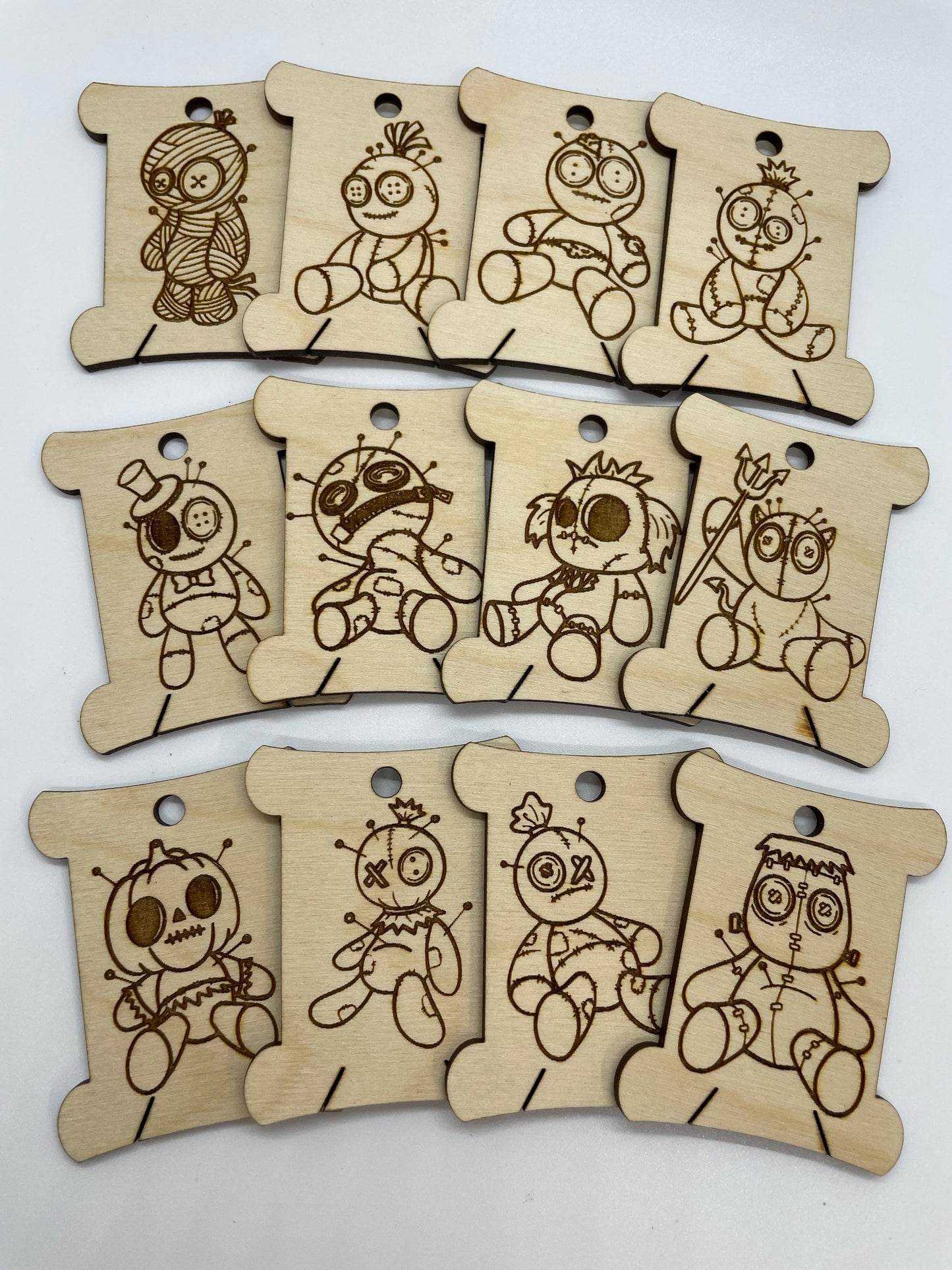 Set of wooden tags with engraved voodoo figure designs on a white background