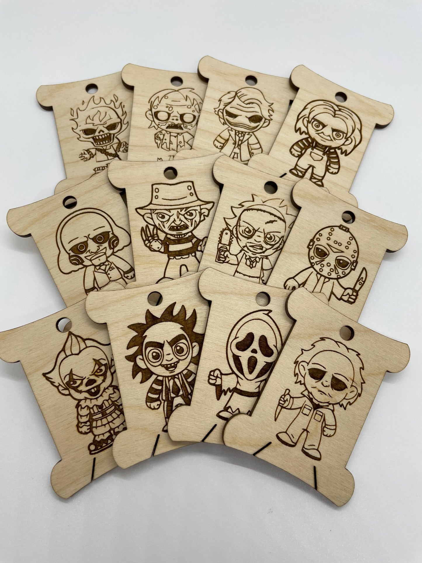 Set of wooden keychains with engraved character designs on a white background