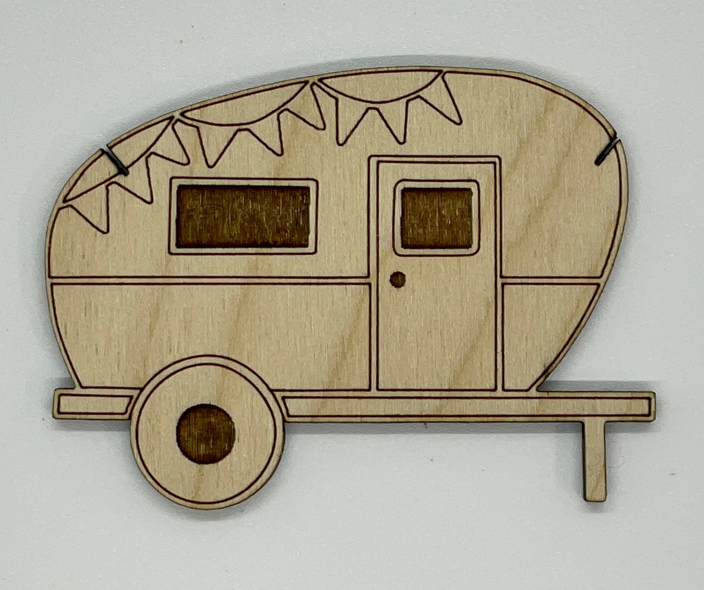Wooden model of a camper trailer with bunting on a white background