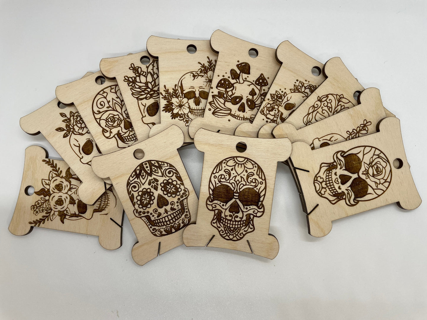 Wooden tags with skull and floral designs on a white background