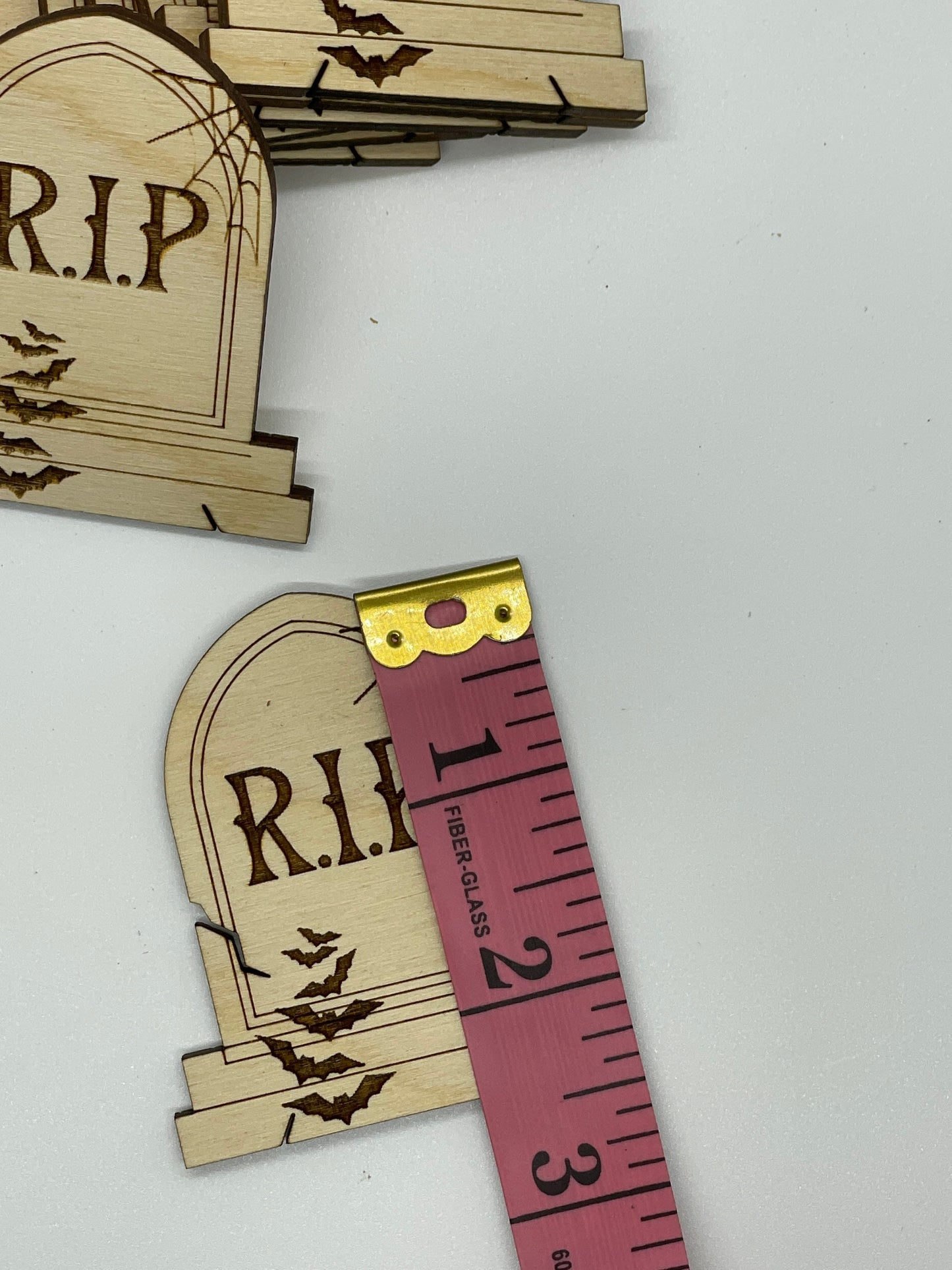 Wooden tombstone cutouts with 'R.I.P.' engraving on a white background