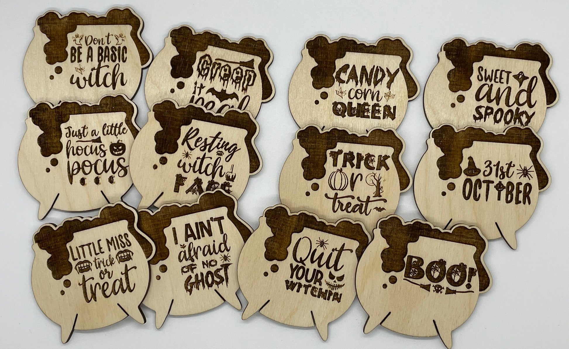 Set of Halloween-themed wooden cutouts with various sayings on a light gray background