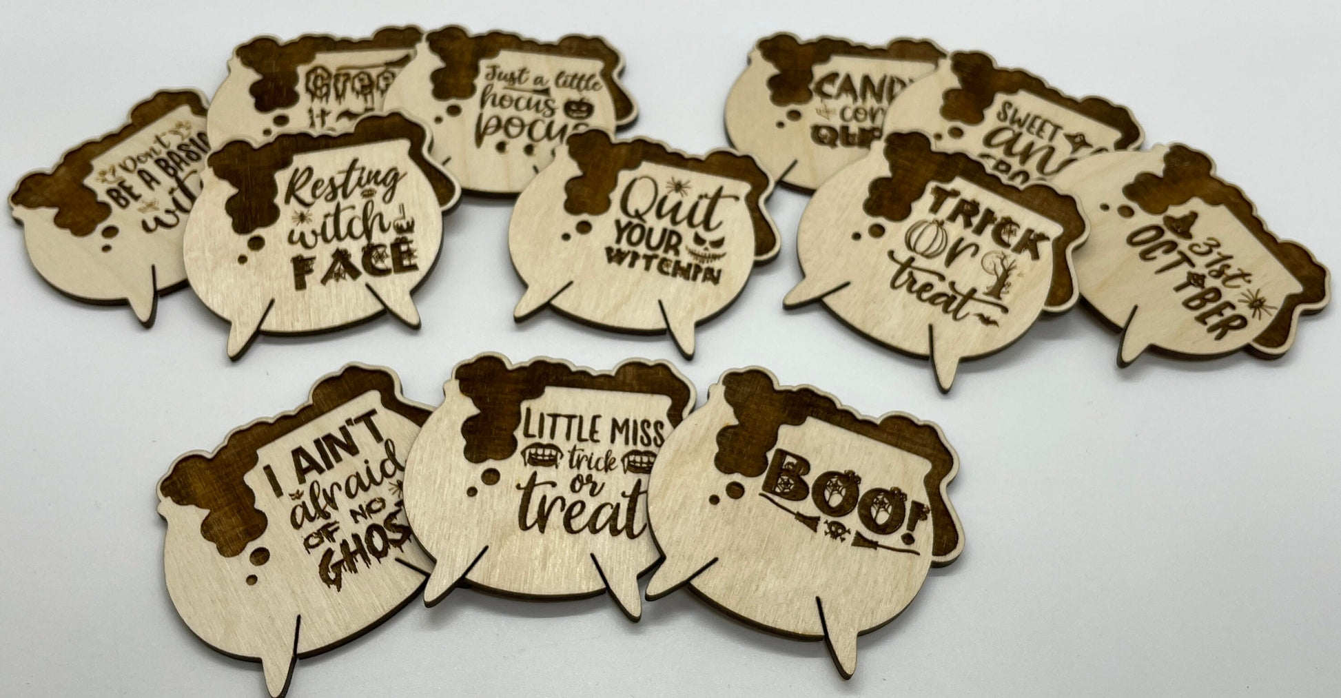 Wooden Halloween-themed cauldron bubble decorations on a white background