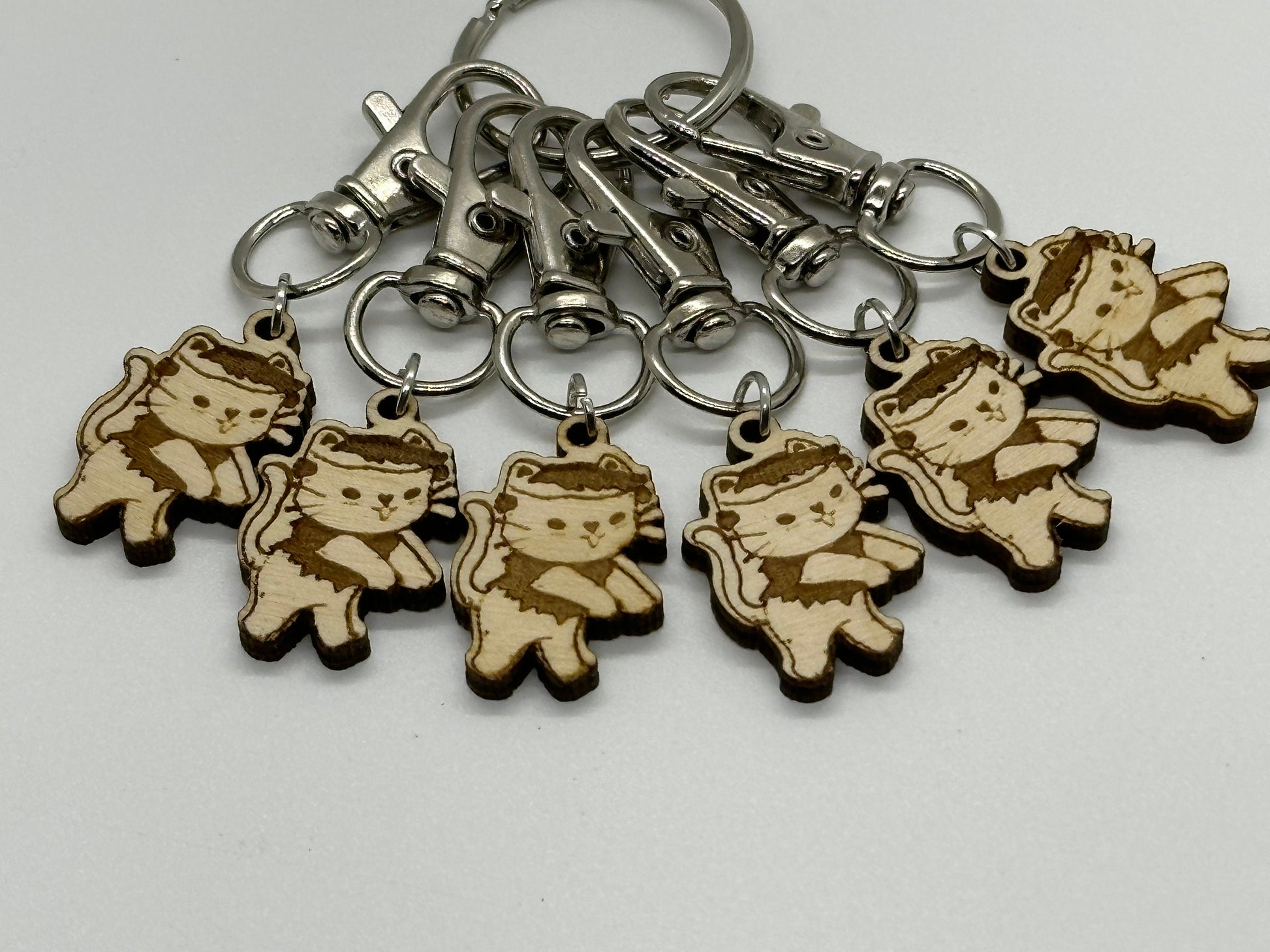 Set of keychains with wooden charms shaped like cartoon characters on a white background