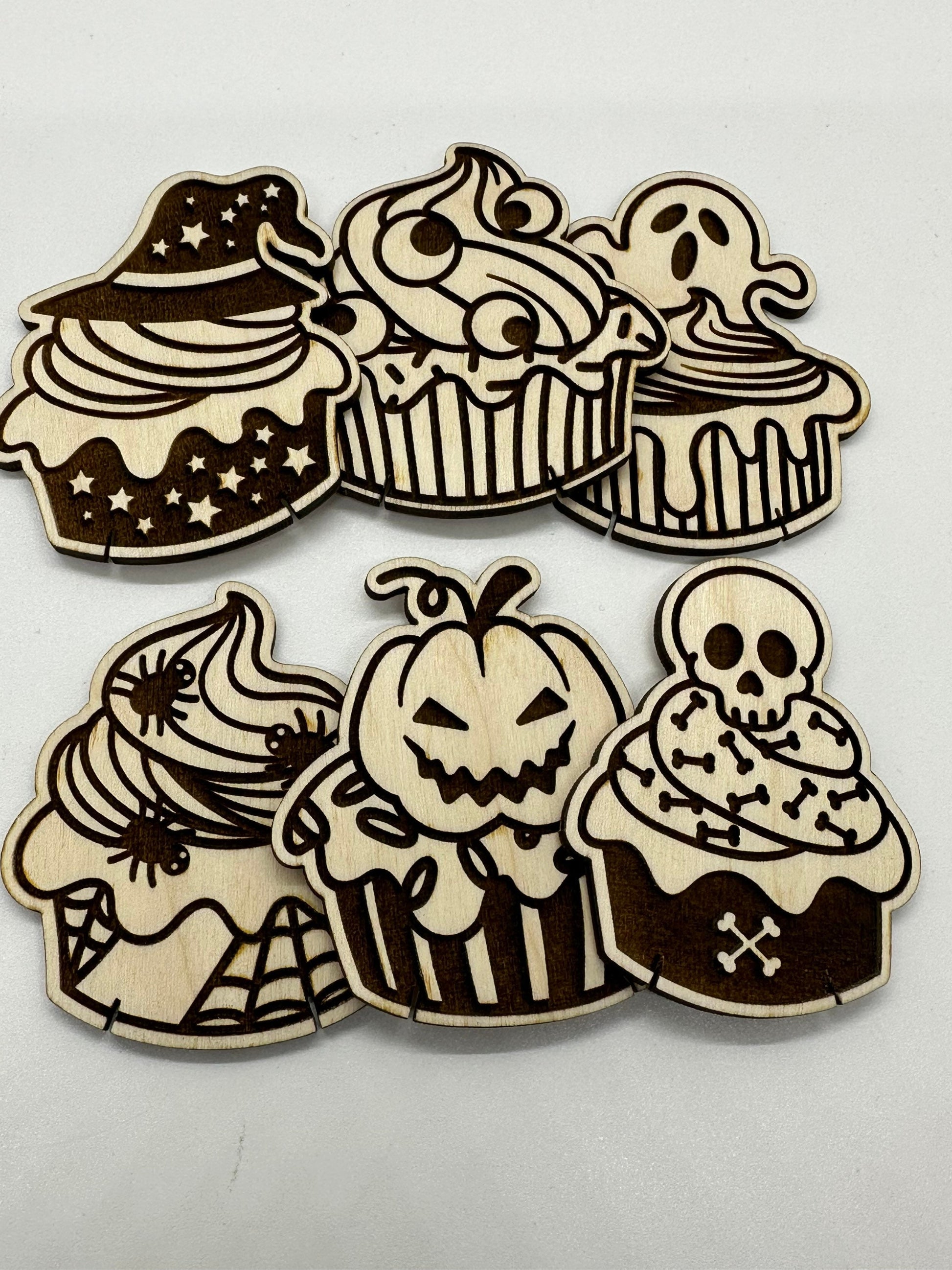 Set of Halloween-themed wooden cupcake cutouts on a white background