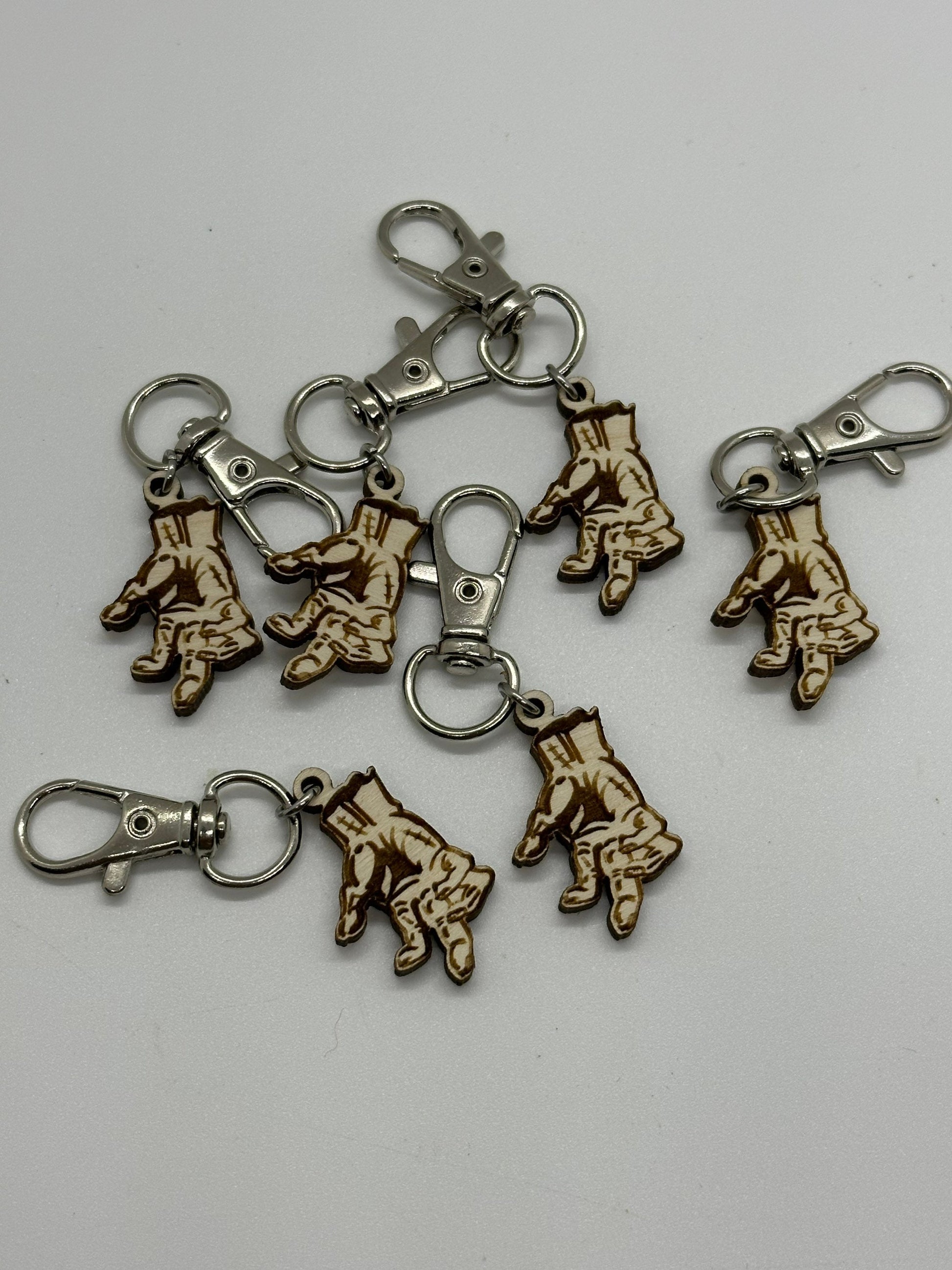 Set of keychain charms with hand prints on a white background