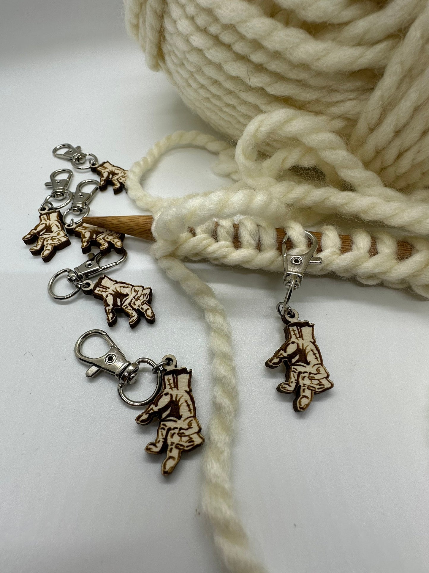 Knitting needle charms with hand patterns on a white background