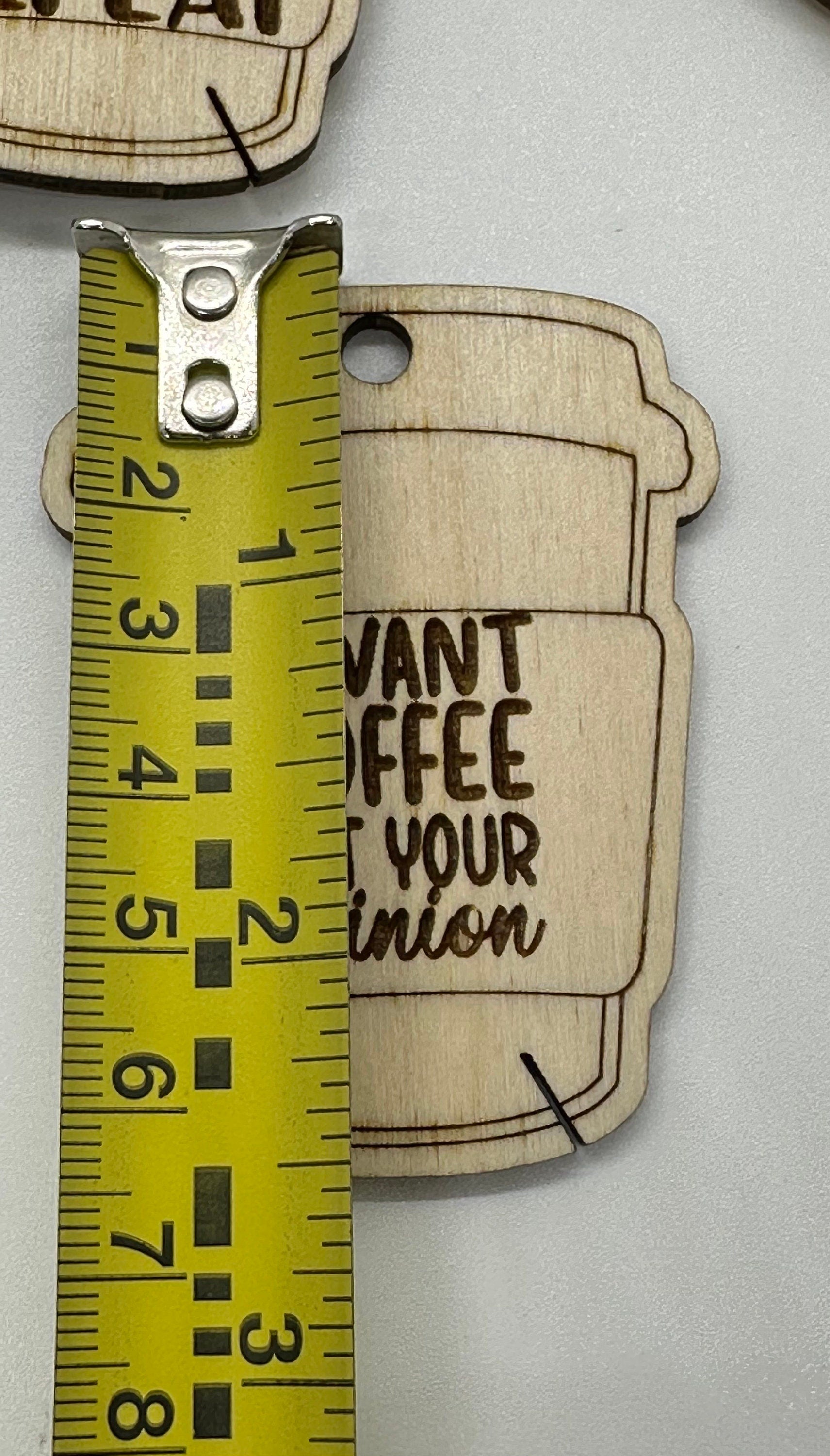 Close up of laser engraved coffee quote detail on birch plywood bobbin with ruler