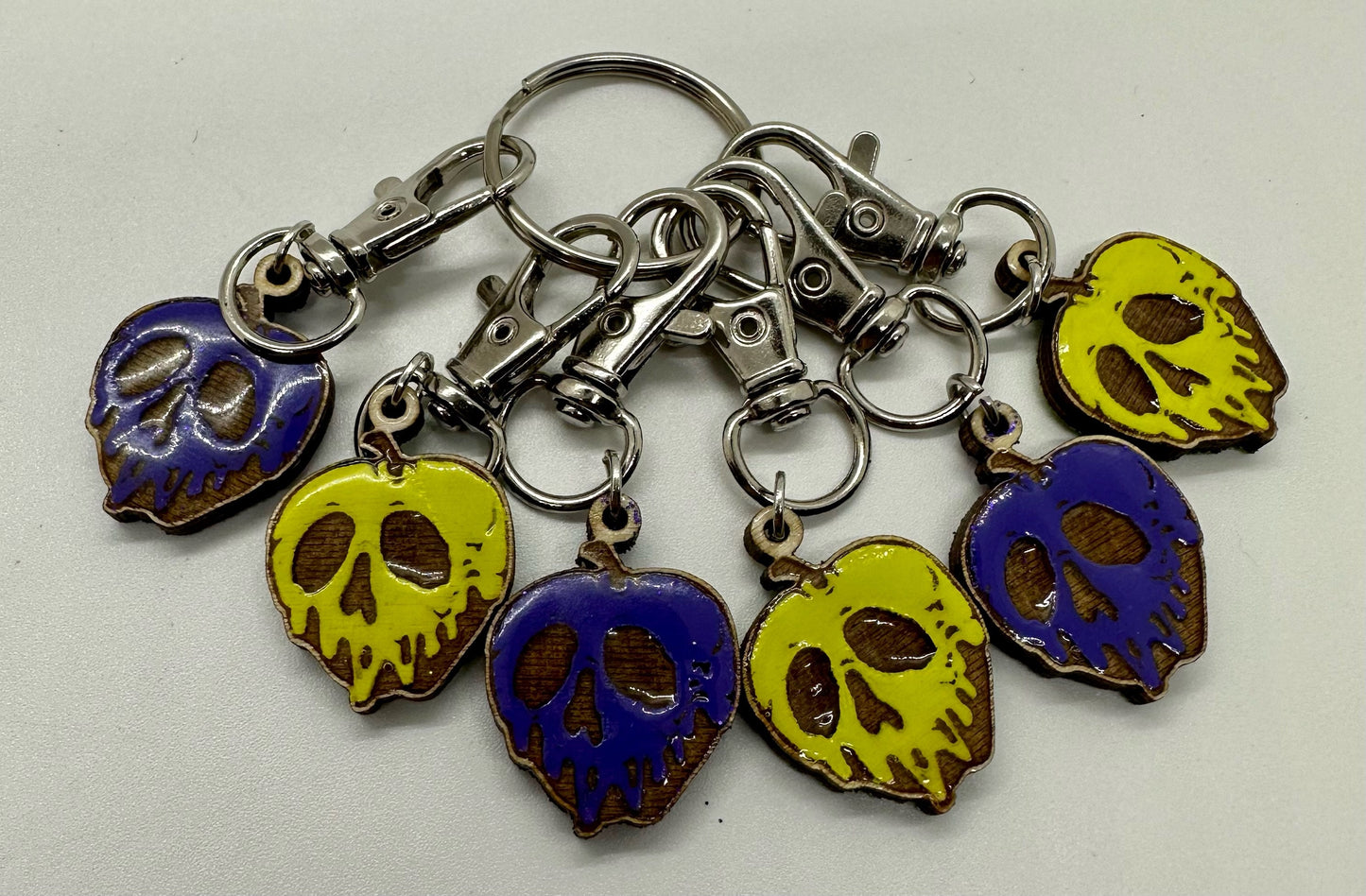 Set of colorful skull-shaped keychains on a white background
