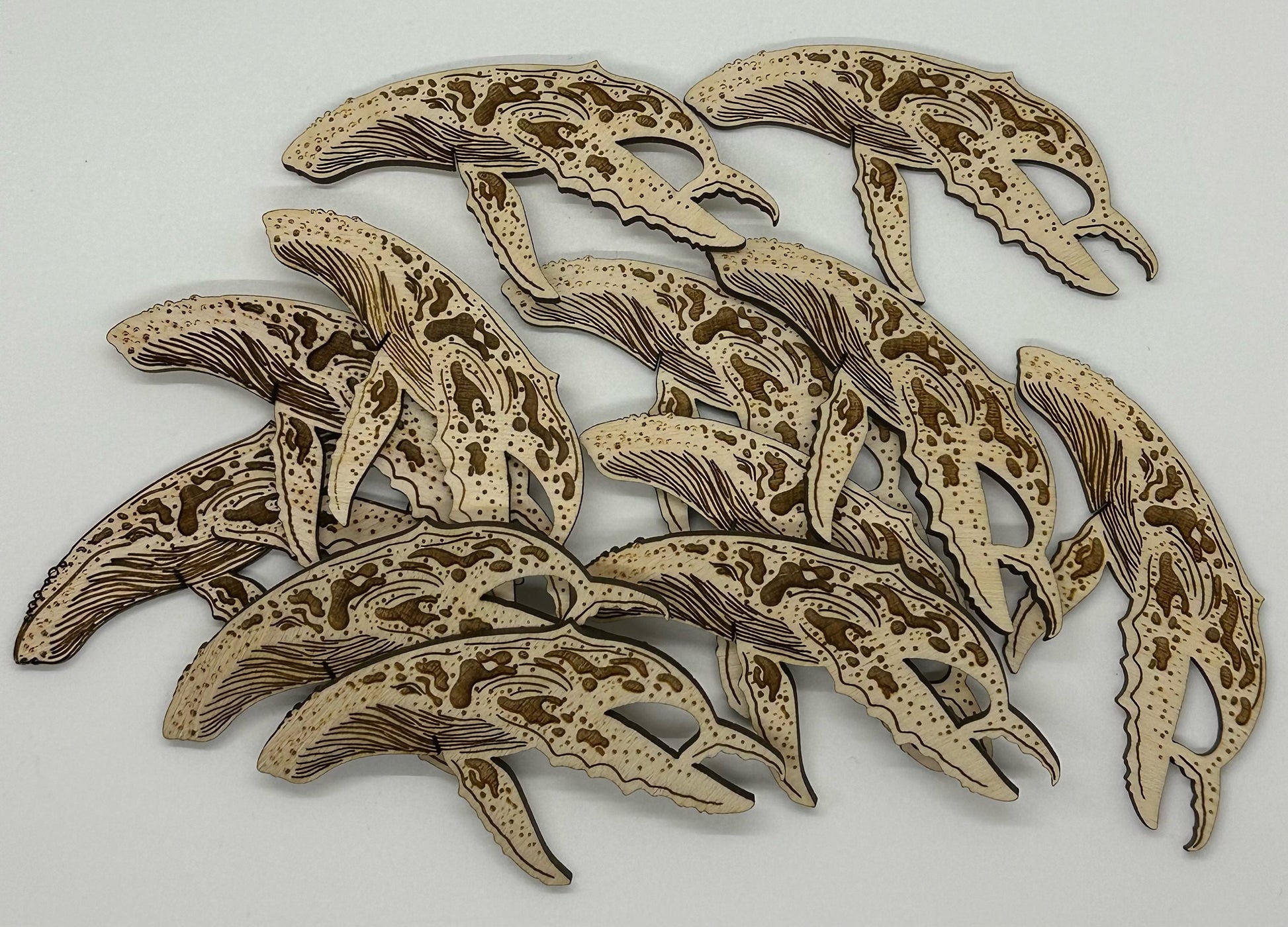 Wooden humpback whale cutouts on a white background