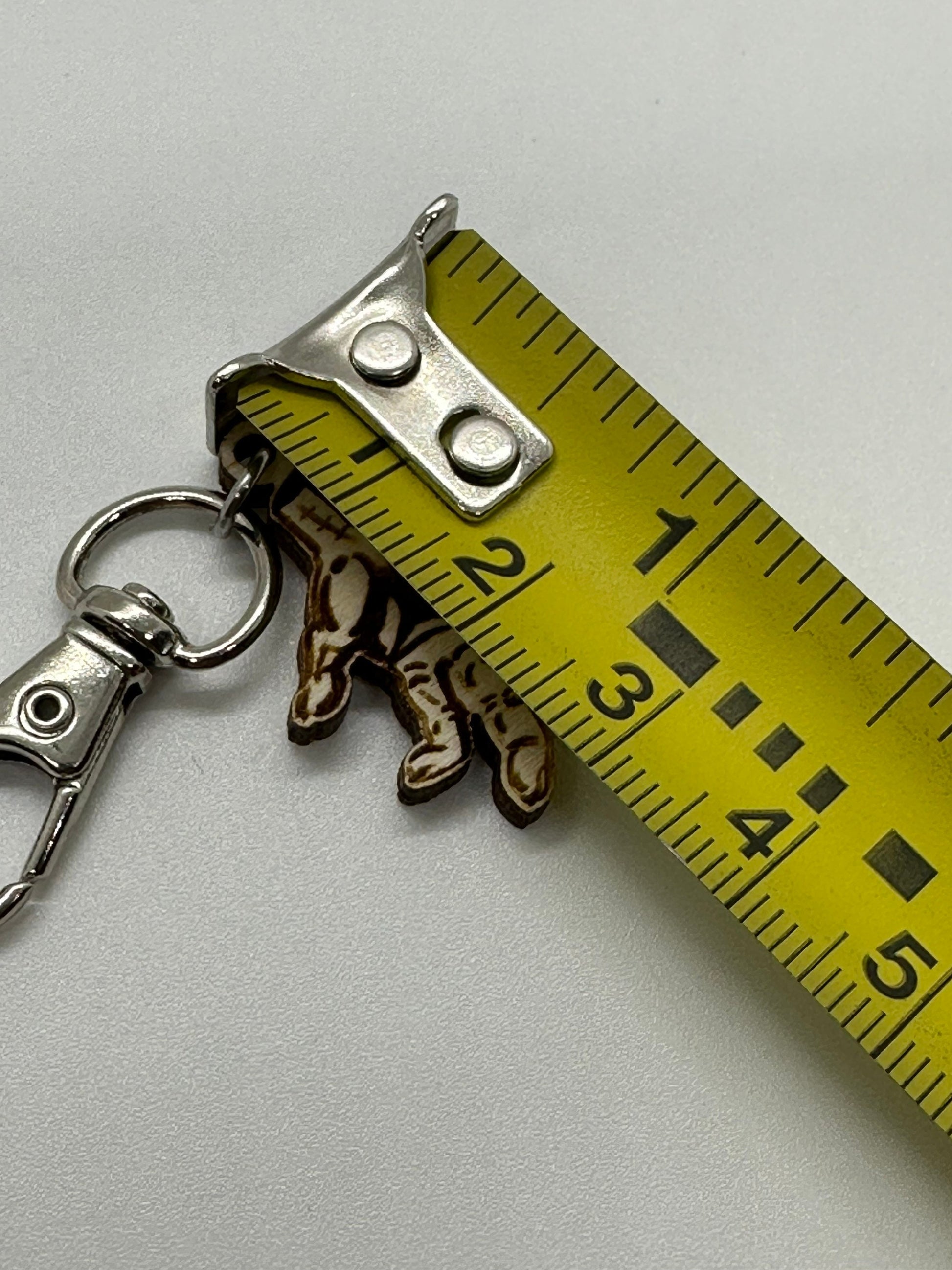 stitch marker with a measuring tape for scale on a light gray background
