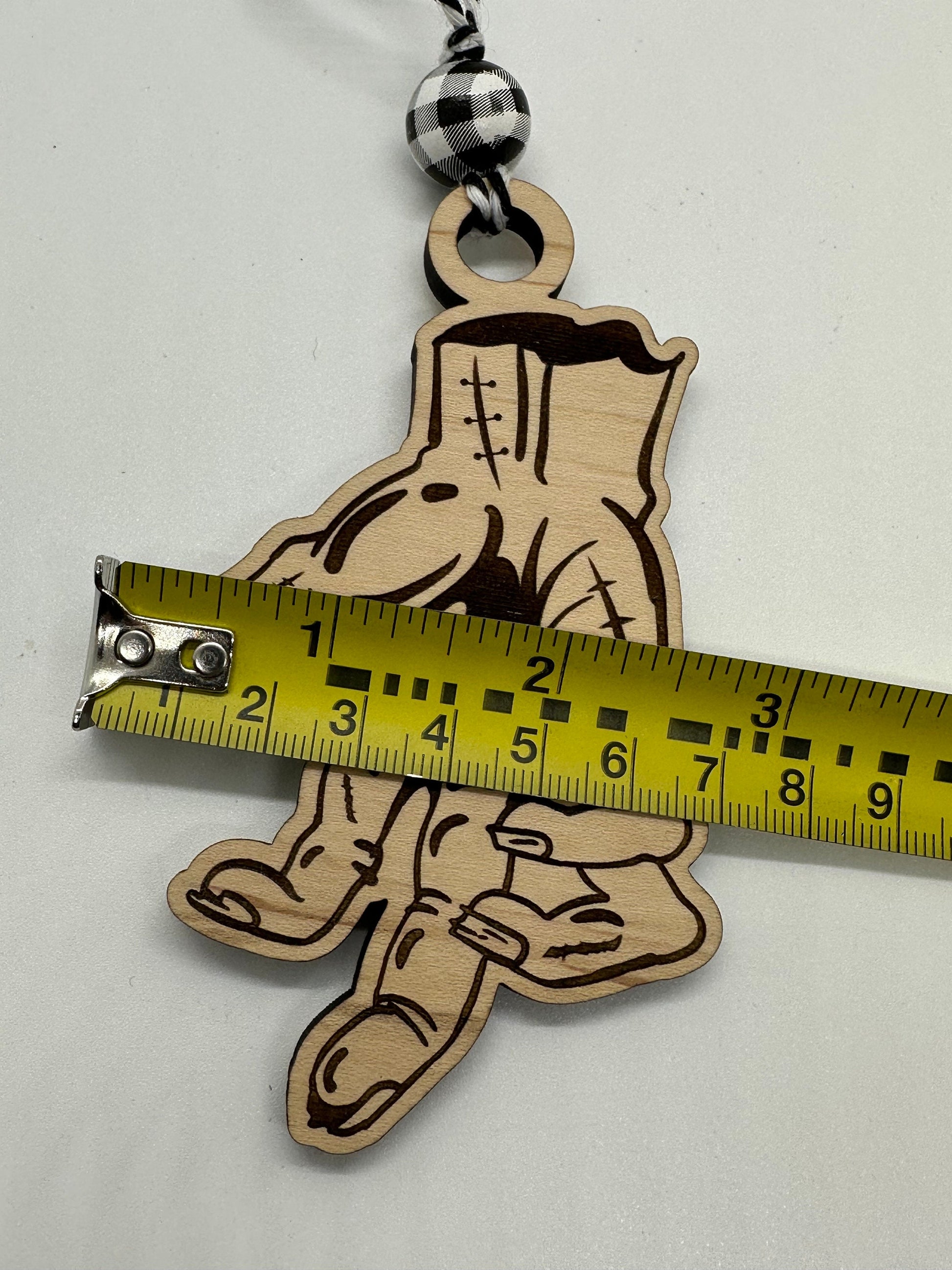 Wooden hand-shaped ornament with a measuring tape for scale on a white background