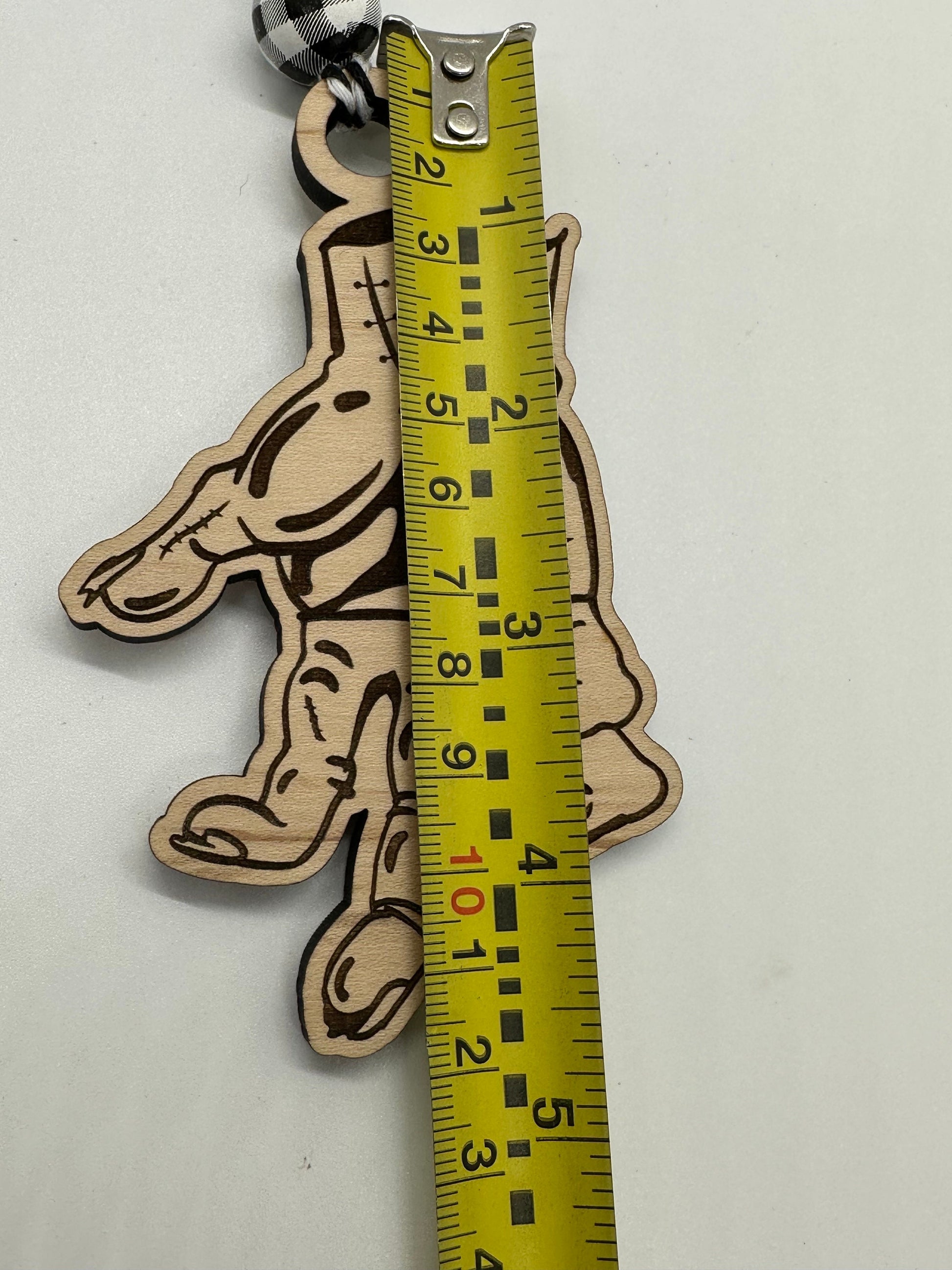 Wooden hand-shaped keychain with a tape measure attached, showing measurement details.