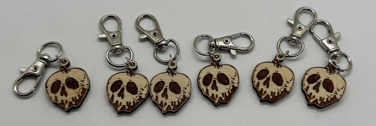 Set of five skull-shaped keychains with metal clips on a white background