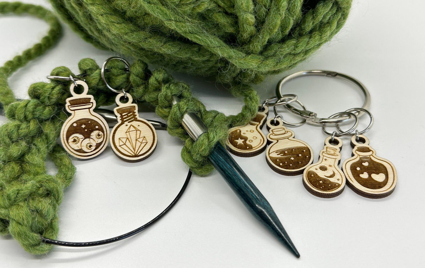 Yarn with knitting needles and decorative charms on a white background