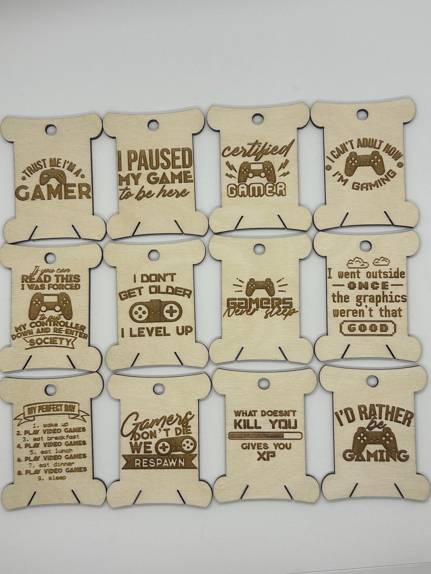 Set of wooden bobbins with gaming-themed sayings on a white background