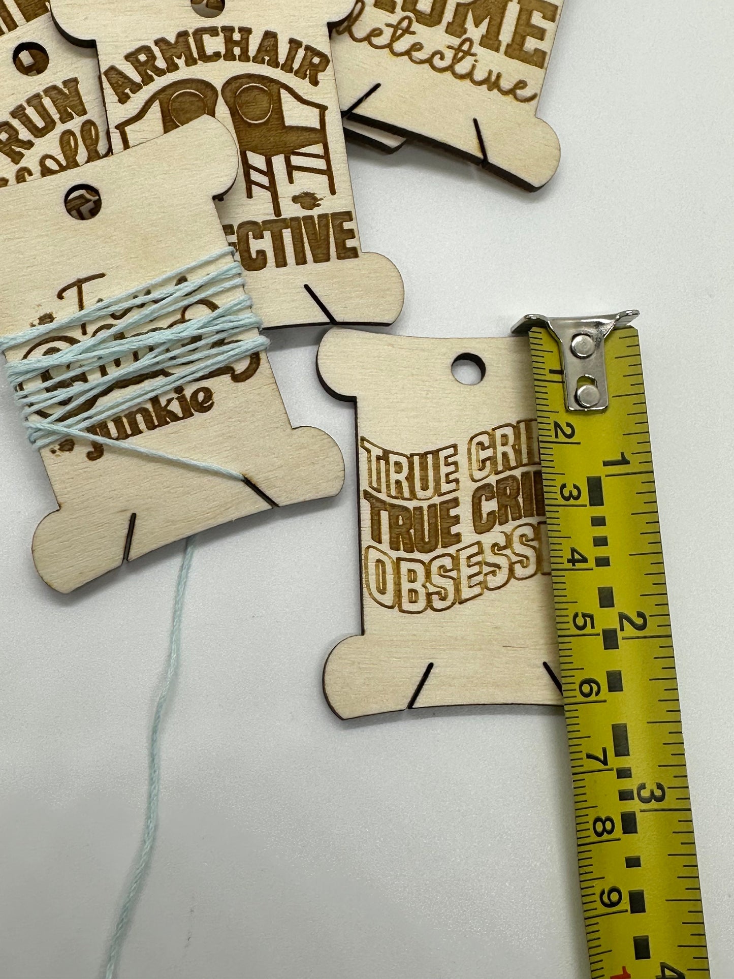 Wooden tags with text and a measuring tape for scale on a white background