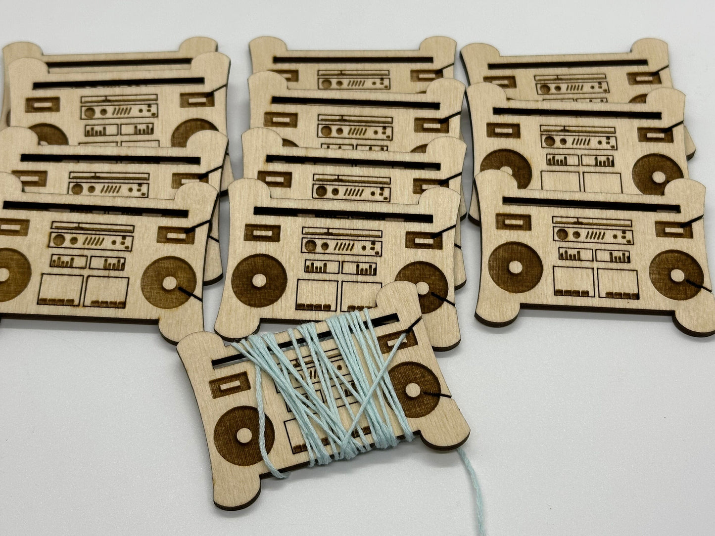 Wooden bobbins with cassette tape and boombox design on a white background