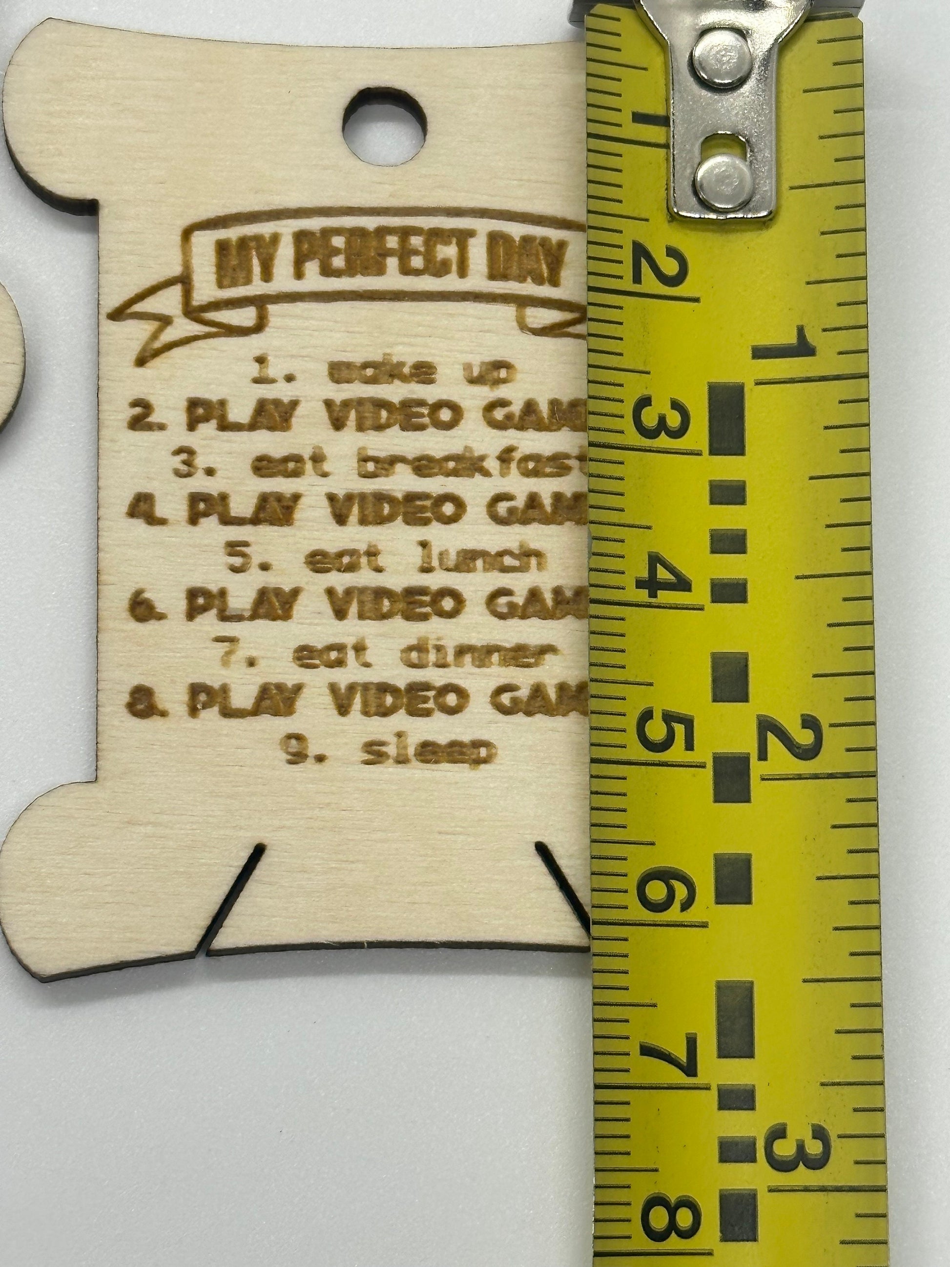 Wooden bobbins with 'My Perfect Day' list next to a measuring tape