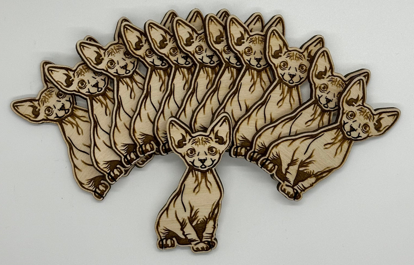 Wooden cutout of a cat in a star-like arrangement on a white background