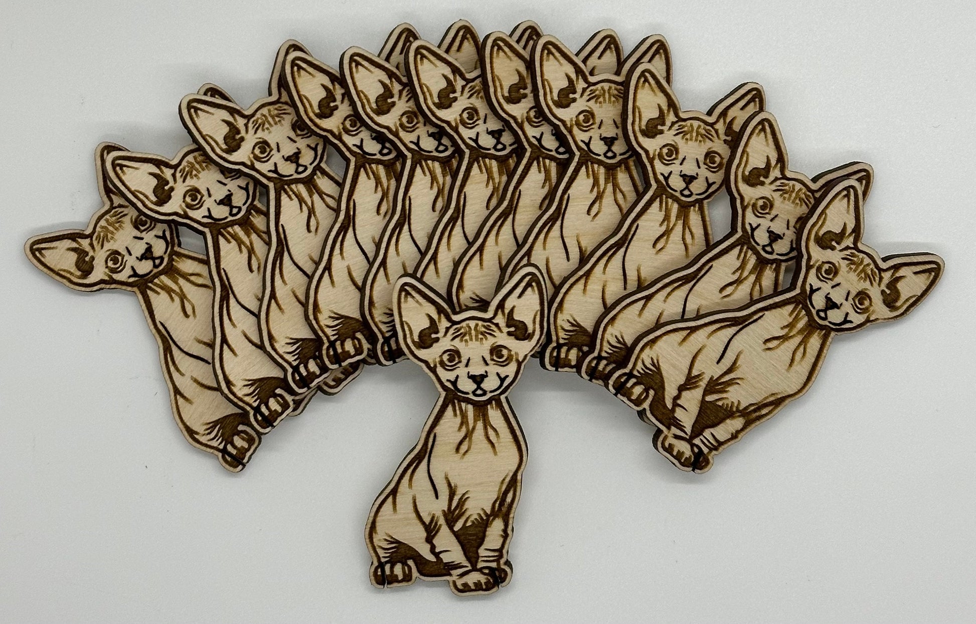 Wooden cutout of a cat in a star-like arrangement on a white background