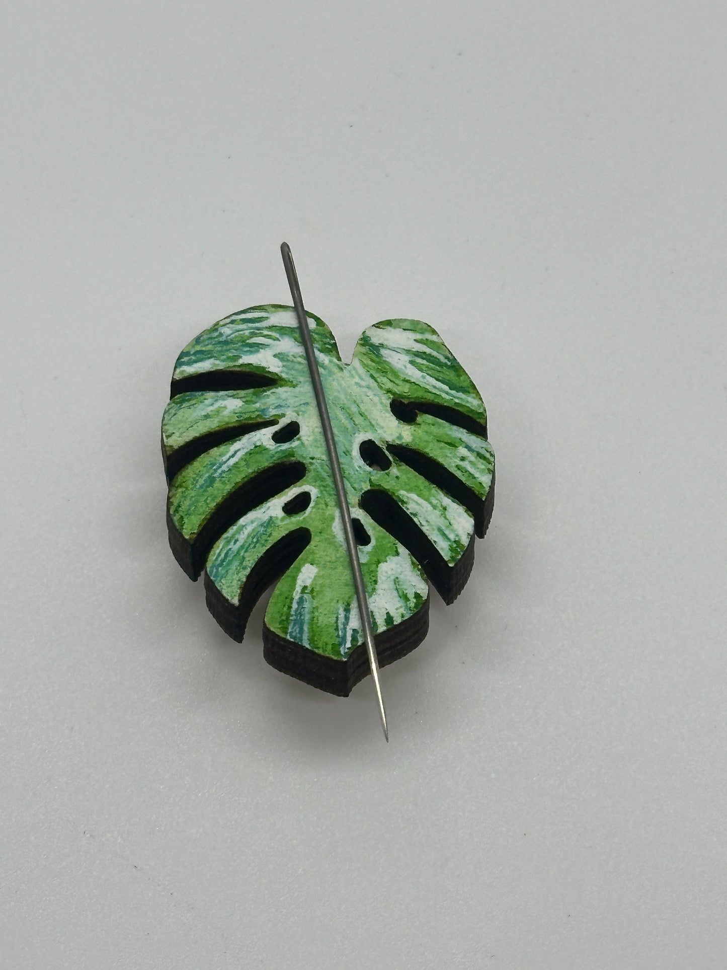 Green leaf-shaped minder on a gray background