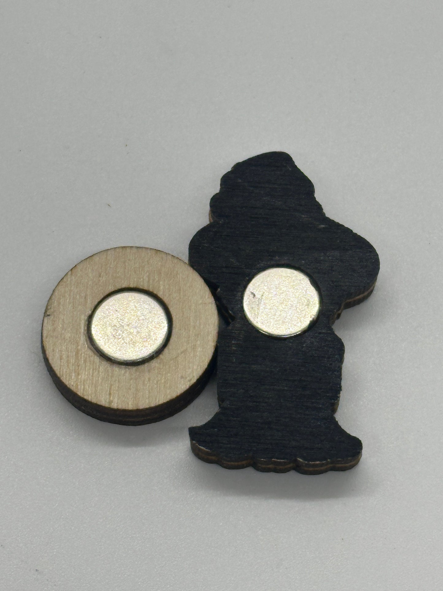 Two round metallic objects with black and beige bases on a gray background