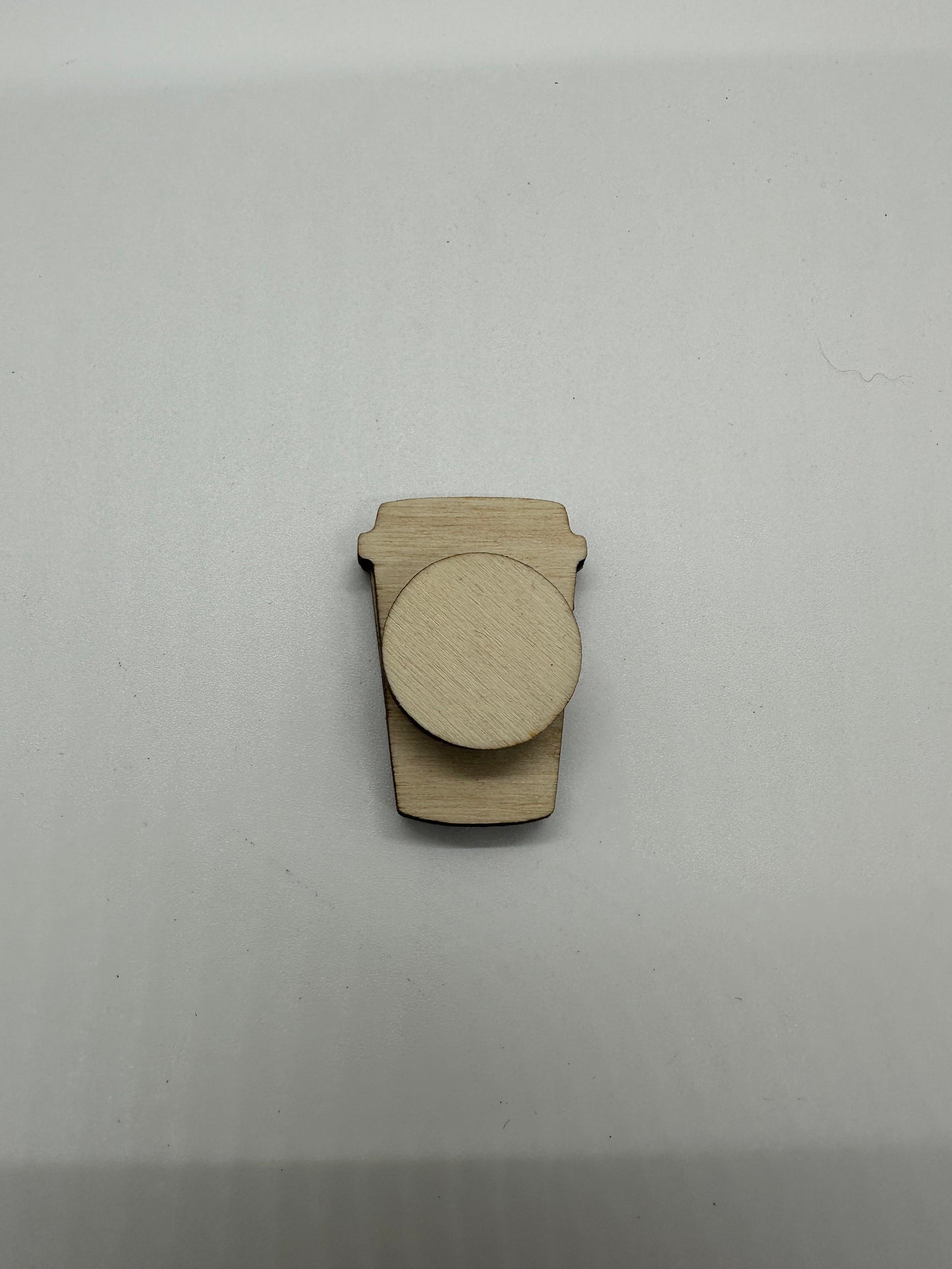 Wooden cutout of a coffee cup on a white background