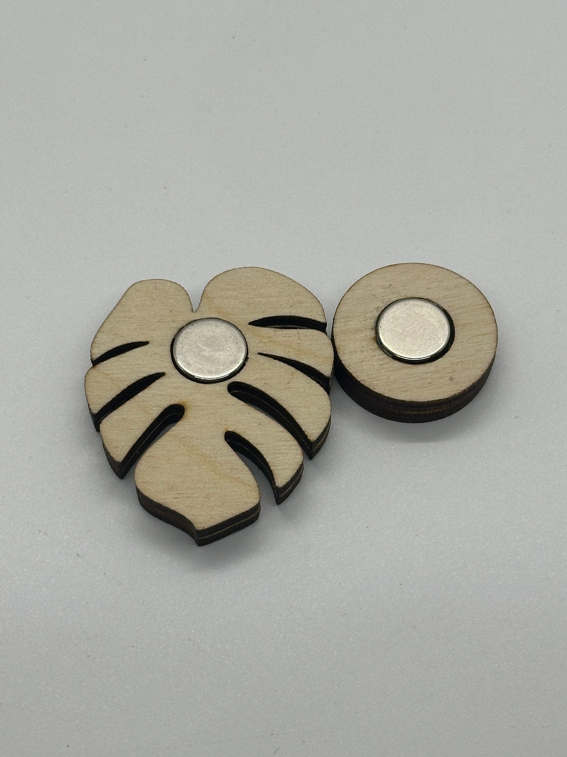 Wooden needle minder with leaf design on a gray background