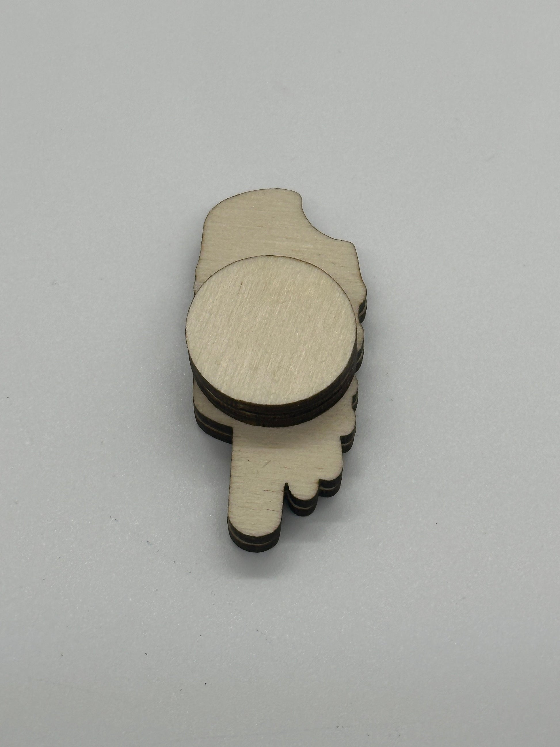 Wooden cutout of a back of needle minder on a gray background