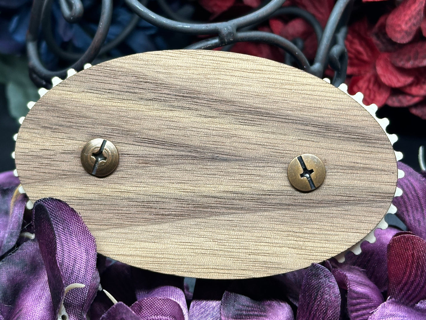 Wooden oval object with metal fasteners on a floral background