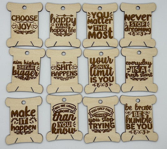 Wooden spools with motivational phrases on a light gray background