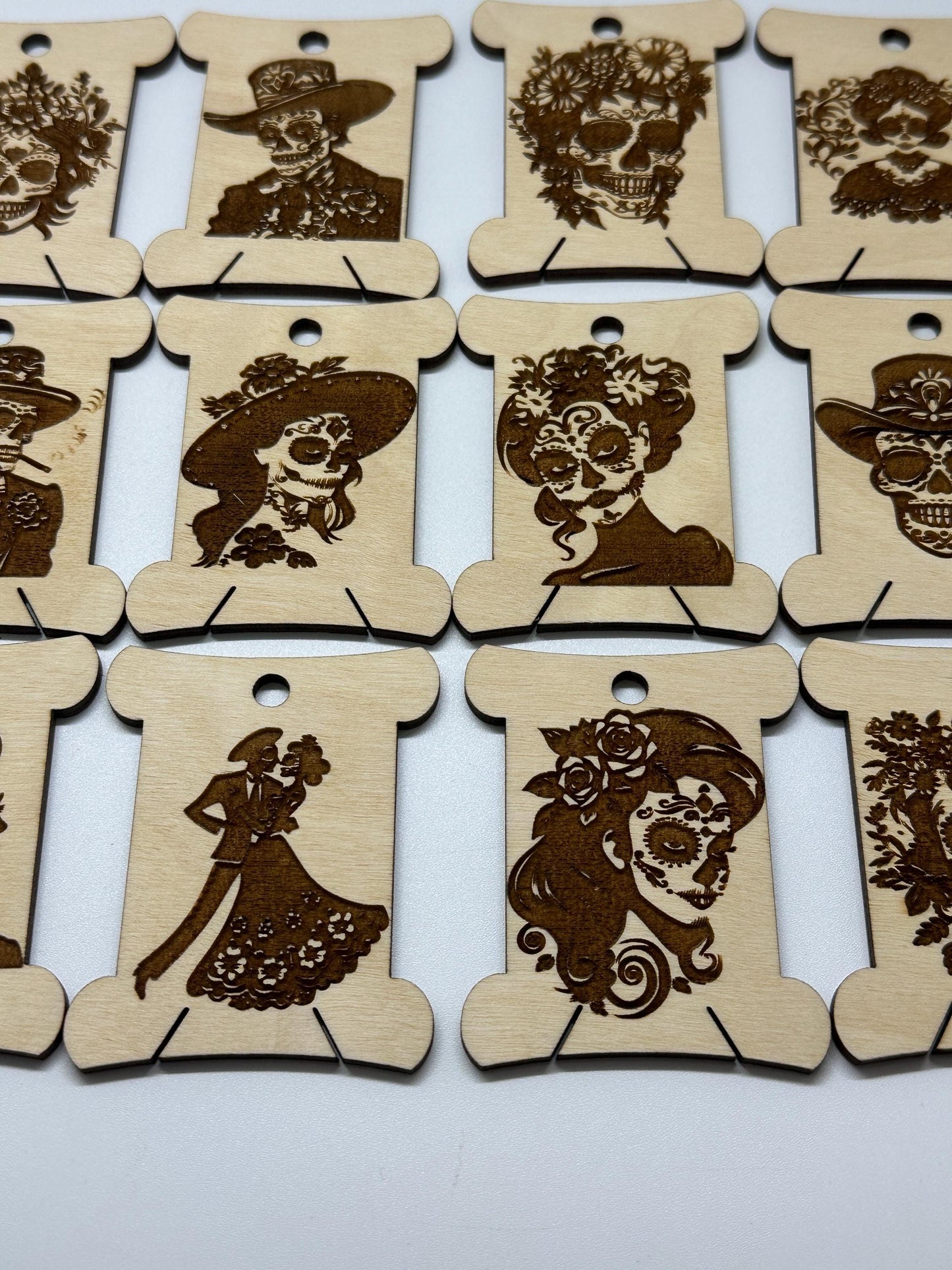 Set of wooden bobbins  with laser-cut designs on a white background
