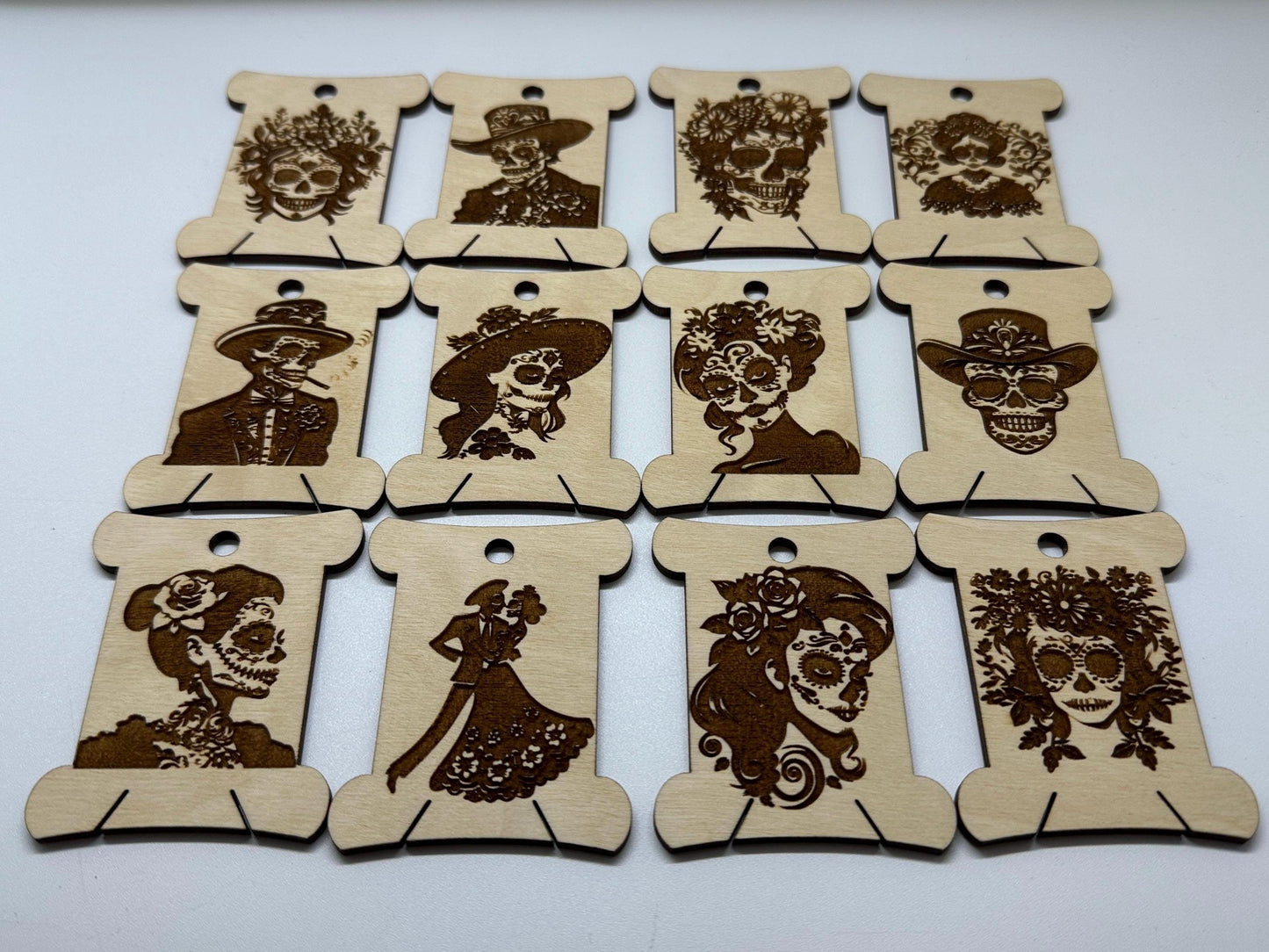 Set of wooden bobbins  with laser-cut designs of faces on a white background
