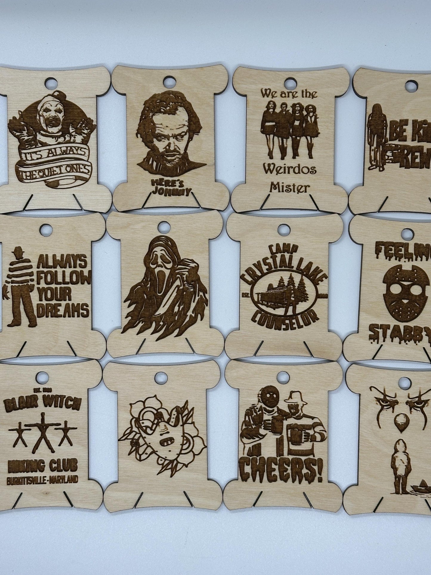 Set of wooden tags with laser-cut designs and text on a white background