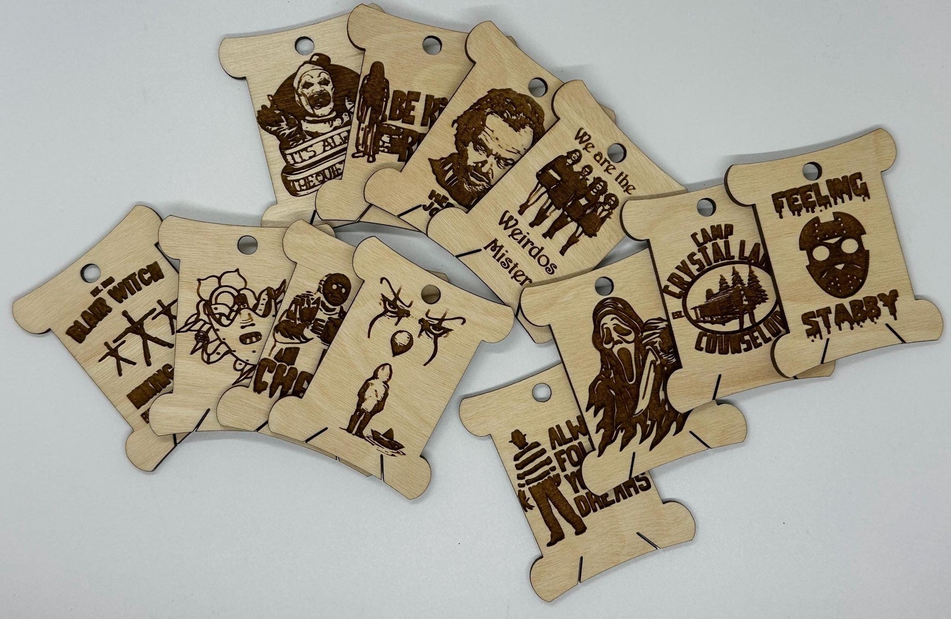Set of wooden tags with engraved designs and text on a light gray background