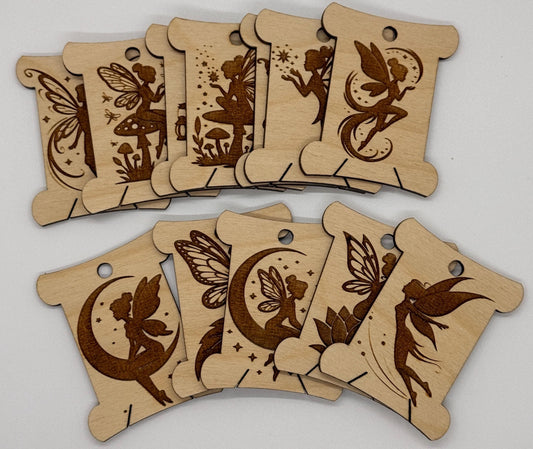 Wooden tags with engraved fairy designs on a white background