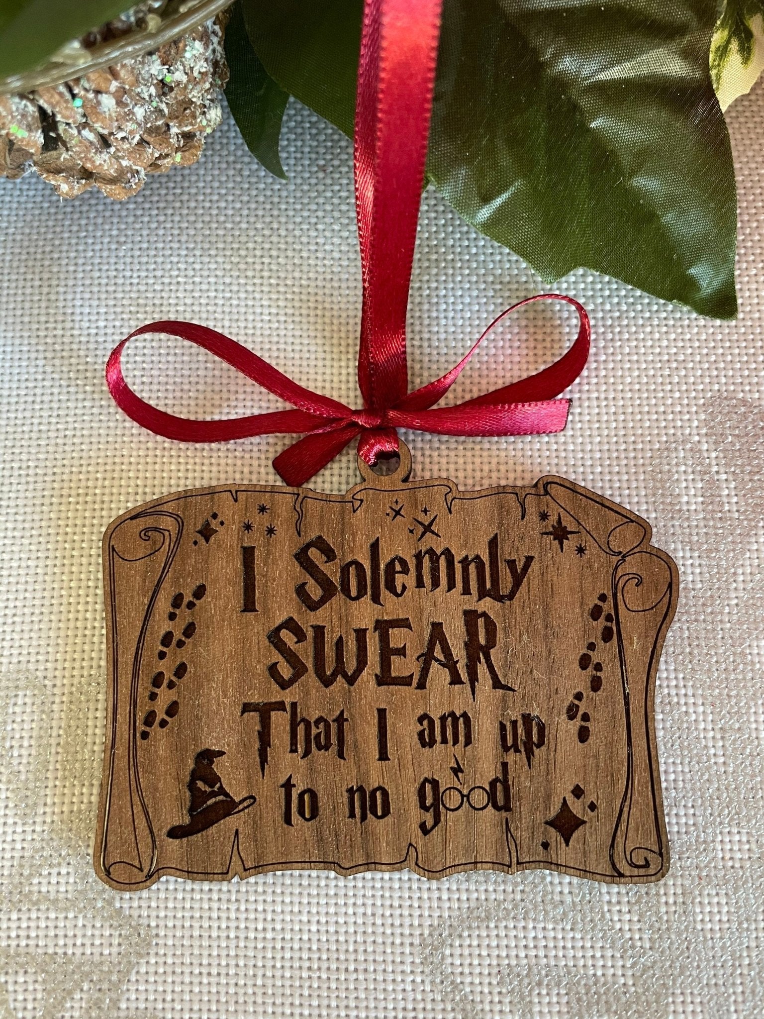 Laser engraved wooden I Solemnly Swear Christmas ornament on white background, scroll design on birch plywood